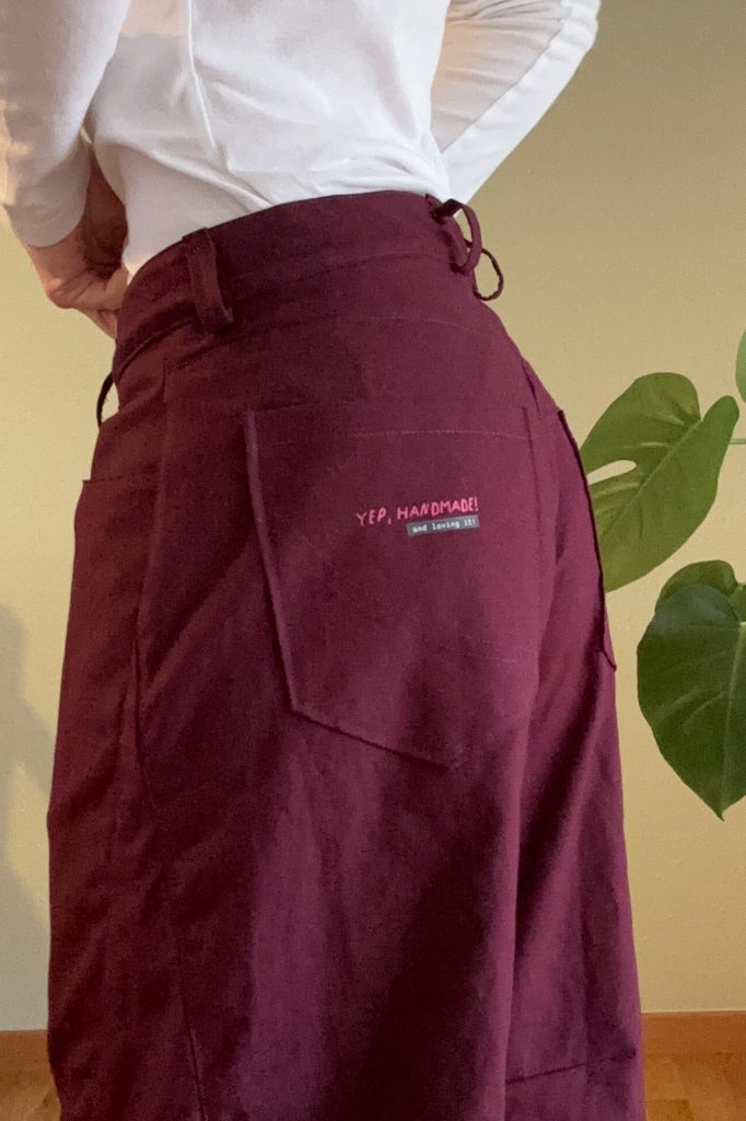 Rückansicht mit der Gesäßtasche mit kleinem Bügelbild "Yep, handmade! And lovin it"