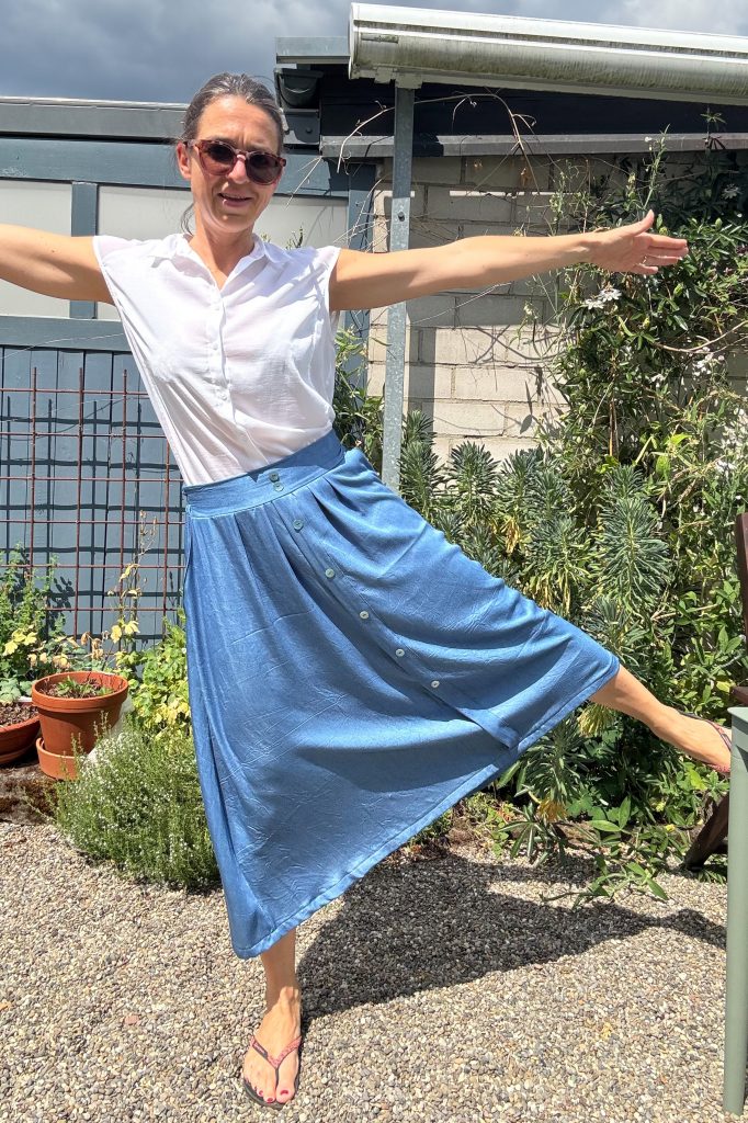 Bild mit zur Seite gestrecktem Bein, das den weiten Fall des Rockes zeigt.