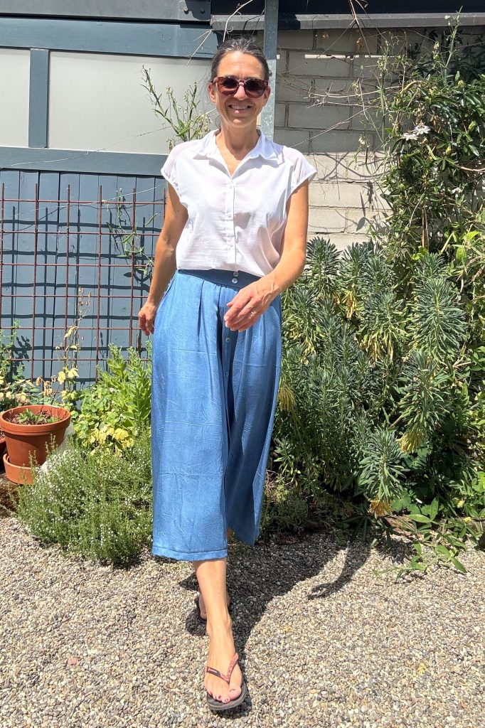 Frontansicht komplett, laufend vom Sommeroutfit: mittelblauer schwingender Rock aus Chambray und weiße Kurzarm-Bluse